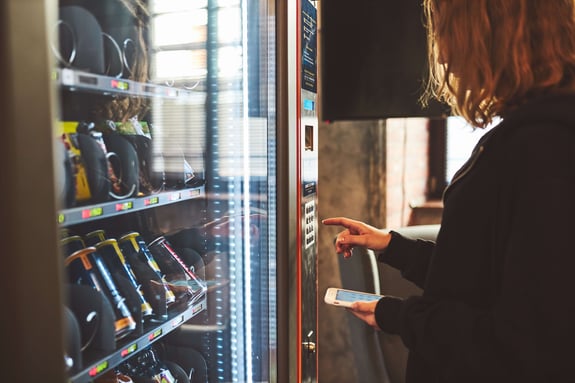 woman-paying-for-product-at-vending-machine-using-2023-11-27-05-20-16-utc-1